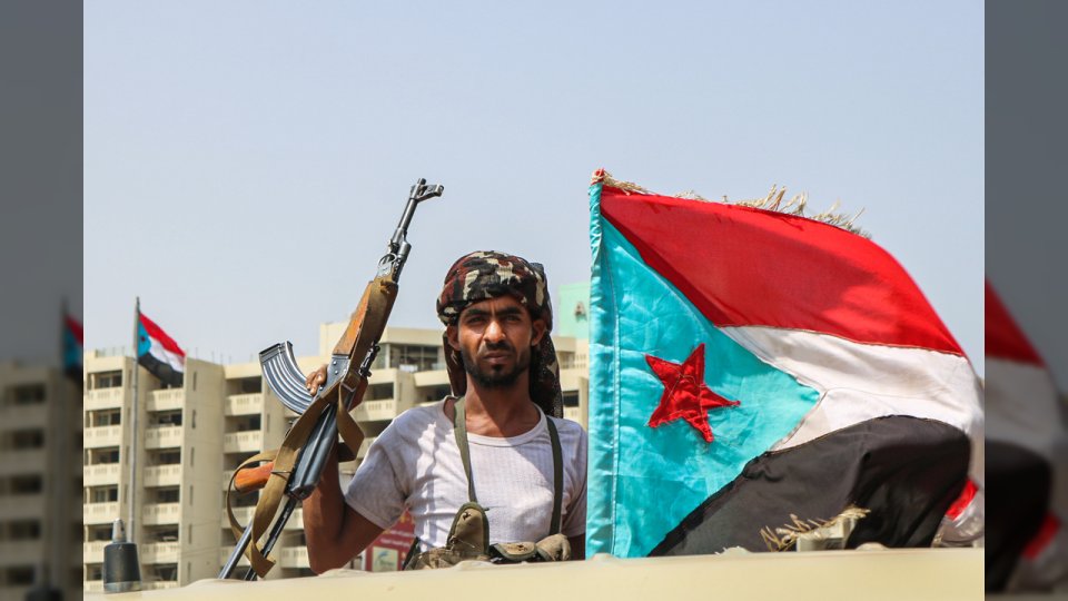 A fighter of the UAE-trained Security Belt Force, dominated by members of the Southern Transitional Council (STC) which seeks independence for south Yemen, poses with a Kalashnikov assault rifle and the southern separatist flag (the old flag of South Yemen), while standing in the back of a pickup truck in the Khor Maksar district of the second city of Aden on August 29, 2019. (Photo by Nabil HASAN / AFP) (Photo credit should read NABIL HASAN/AFP via Getty Images)